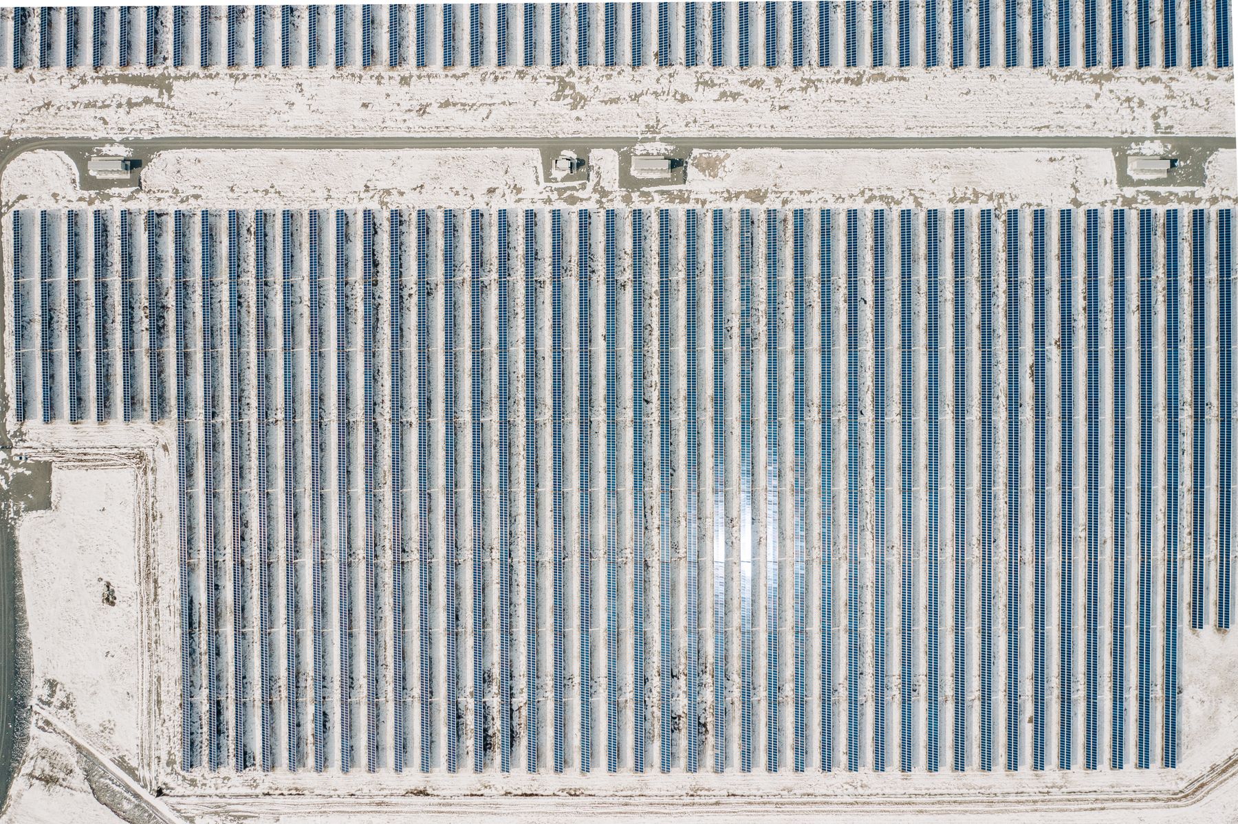 Aerial view of photovoltaic arrays in a rural landscape, illustrative of utility-scale solar development.